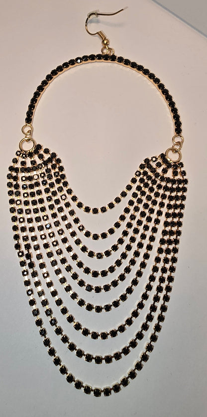 Women’s gold jewelry – black and gold chandelier earrings with layered drops and tiny stones.